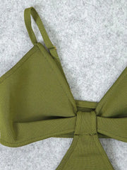 Green bikini top with a bow on a textured gray background
