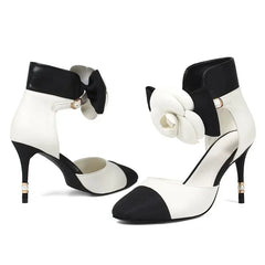Black and white high-heeled shoes with decorative elements on a white background