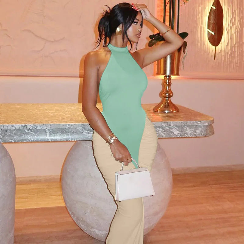 Woman in a green dress holding a white clutch in an elegant indoor setting