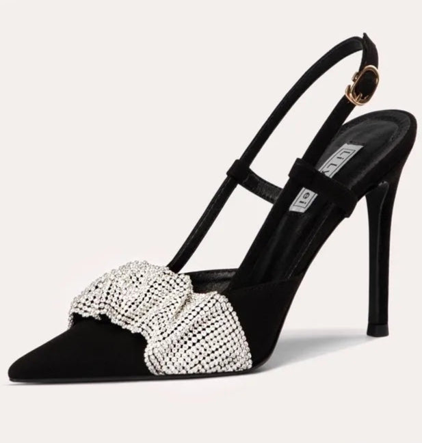 Black high-heeled shoe with a decorative bow on a white background