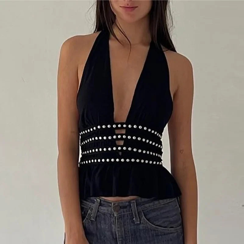 Black halter top with pearl embellishments worn by a person on a plain background
