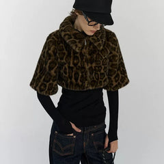 Person wearing a leopard print fur coat over a black top and jeans on a white background