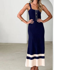 Woman wearing a navy dress with a white hem in a minimal indoor setting