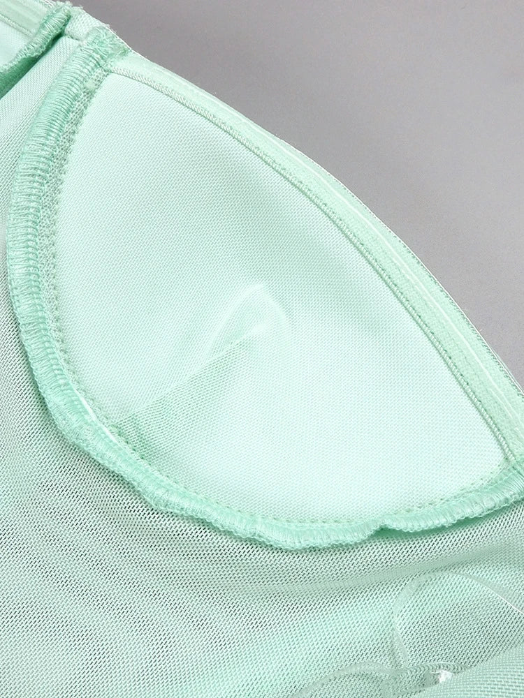 Close-up of a light green fabric with a textured pattern on a gray background