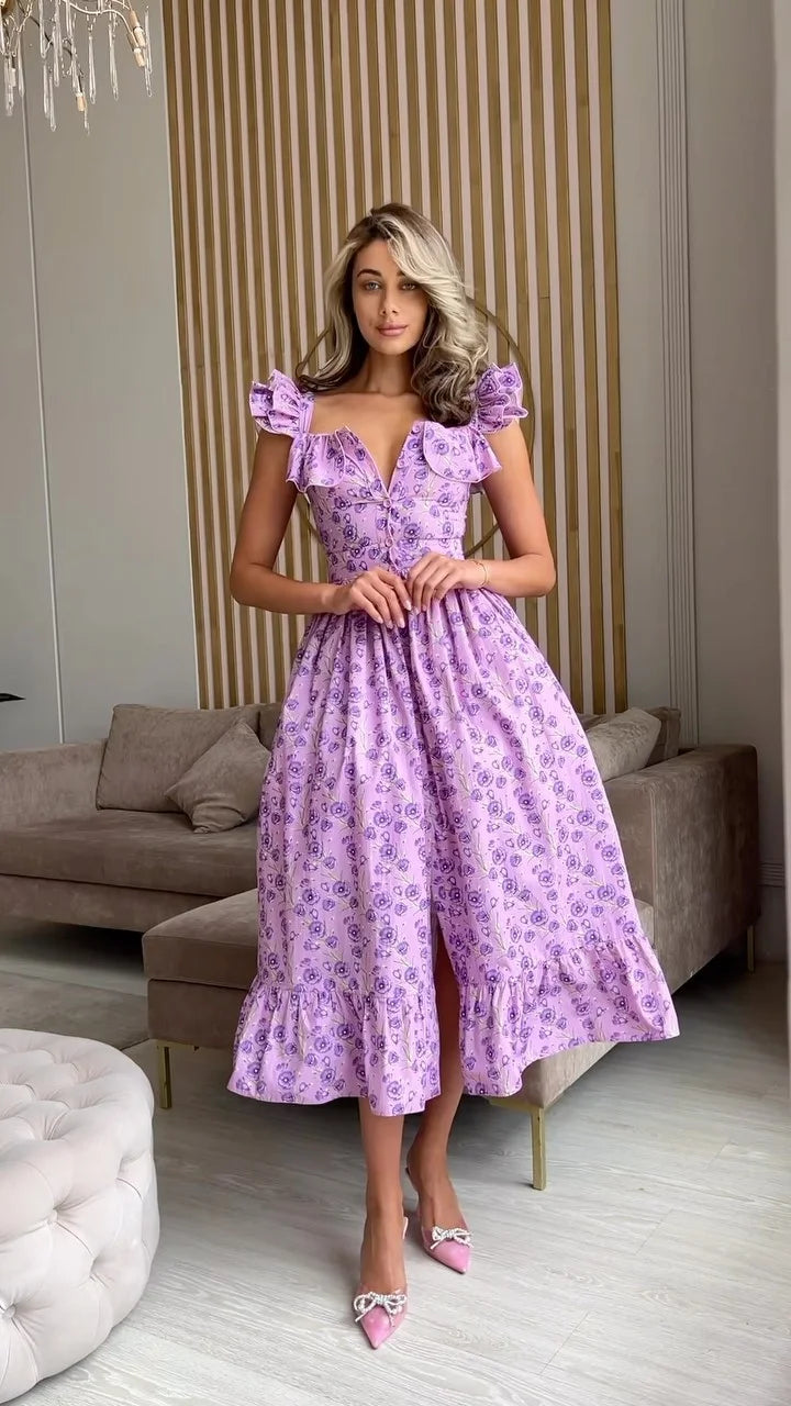 Woman wearing a purple floral dress in an elegant room.