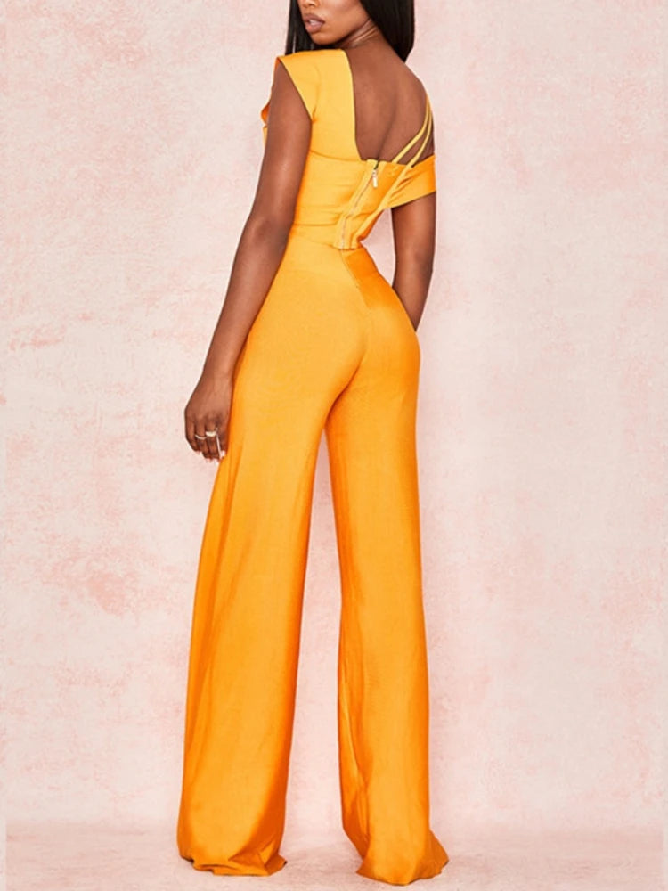 Yellow jumpsuit with cut-out shoulders on a pink background
