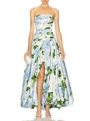 A woman wearing a strapless floral dress with a slit