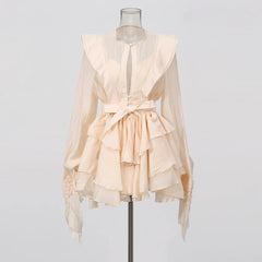 Beige ruffled blouse on a mannequin against a plain background