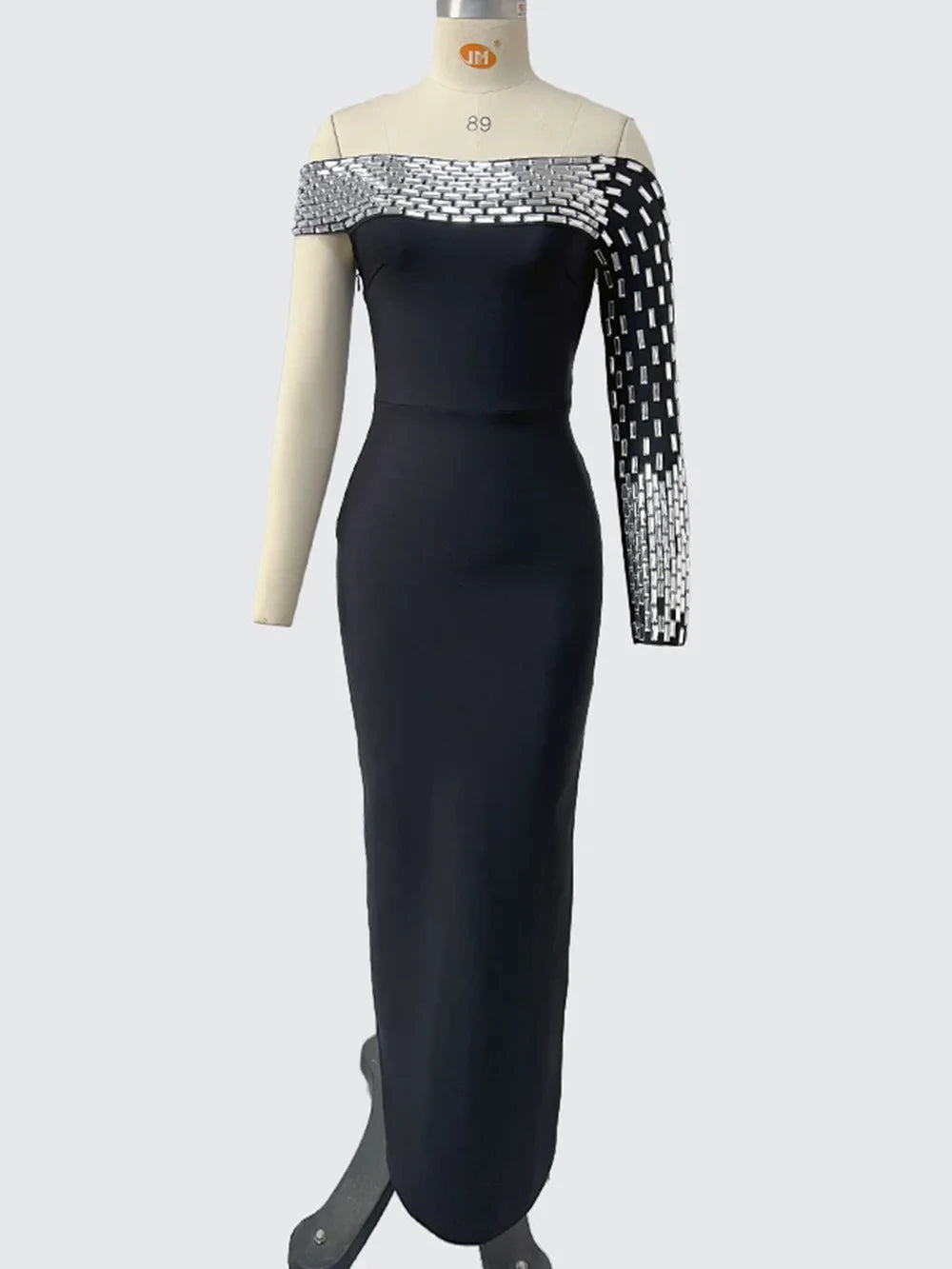 Black evening gown with silver sleeves on a mannequin against a white background