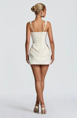 Woman wearing a white dress with thin straps - back view