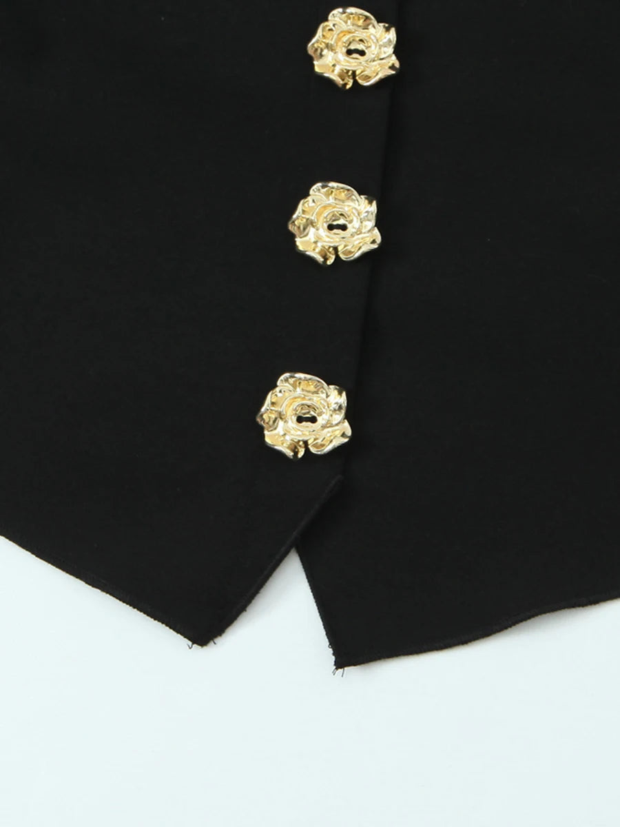 Close-up of a black garment with gold buttons on a white background