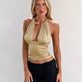 Woman wearing a beige halter top against a plain background