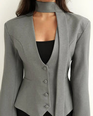 Gray blazer with a black top underneath on a white background