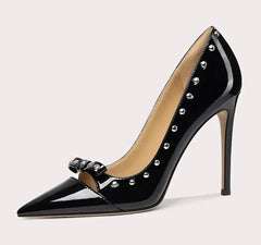 Black high-heeled shoe with studded details on a light gray background