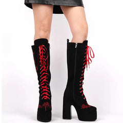 Black knee-high boots with red laces on a white background