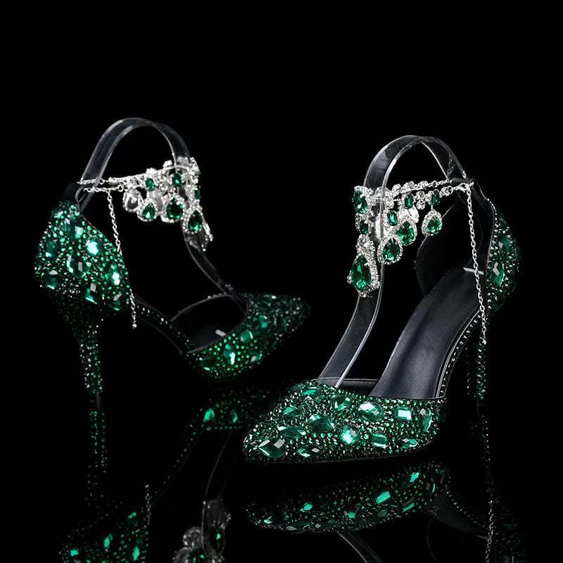 Elegant high-heeled shoes with green gemstones on a black background