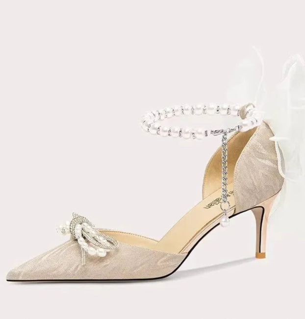High-heeled shoe with decorative strap on a white background