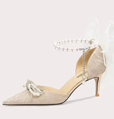 High-heeled shoe with decorative strap on a white background