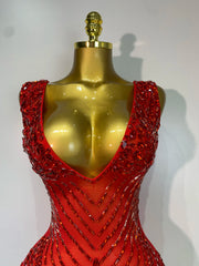 Red beaded dress on a gold mannequin against a white background