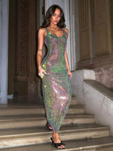 Woman in a sparkling green dress standing on steps indoors