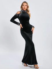 Woman wearing a black evening gown with sequin details on a white background