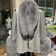 Light-colored leather jacket with gray fur trim on a mannequin in an indoor setting.