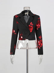 Black blazer with red floral patterns on a mannequin against a gray background