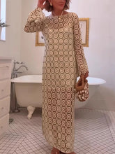 Woman in a patterned dress standing in a bathroom with a bathtub.
