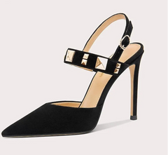 Black high-heeled shoe with studded details on a light gray background