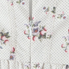 Floral patterned fabric with small black dots on a white background