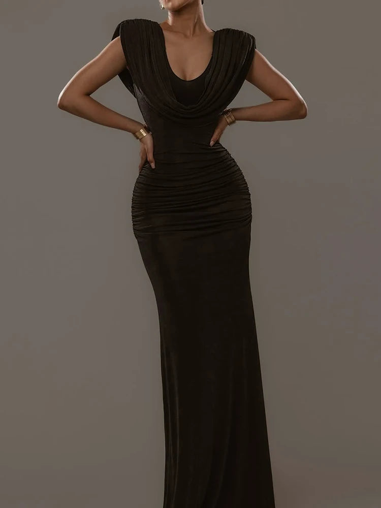 Woman wearing a black evening gown against a gray background