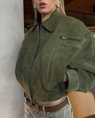 Person wearing a green suede jacket with a blurred background