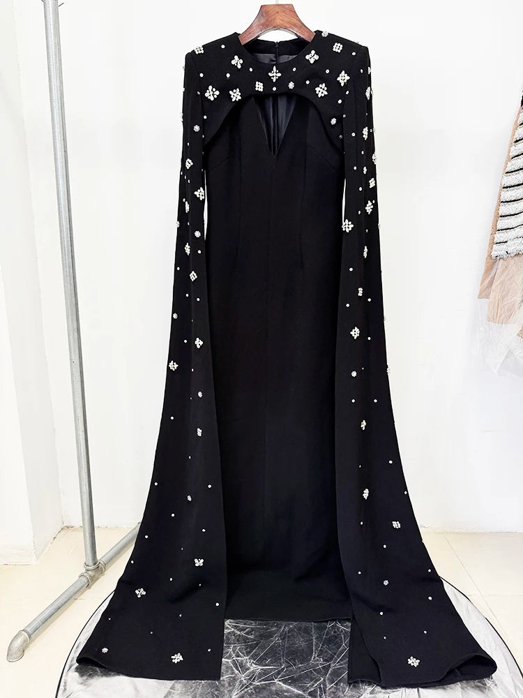 Black maxi dress with beaded cape sleeves on a hanger