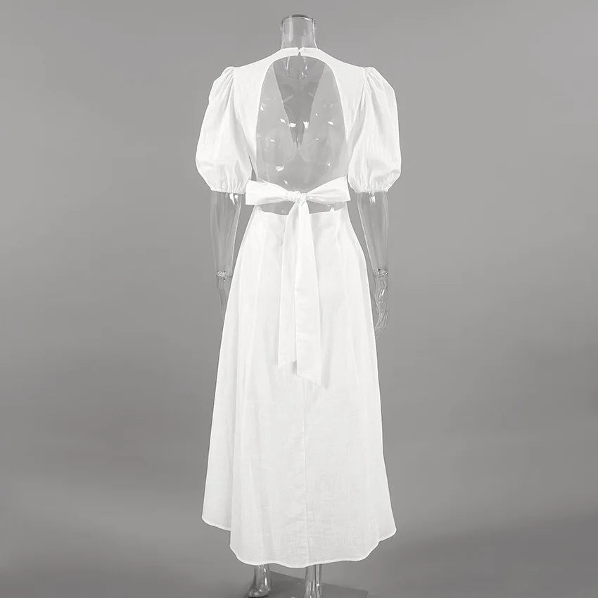 White dress with open back on a mannequin against a gray background