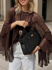 Woman holding a black handbag outdoors
