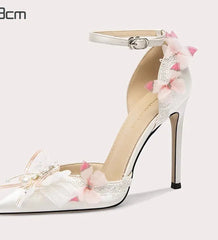 White high-heeled shoe with floral decorations on a white background