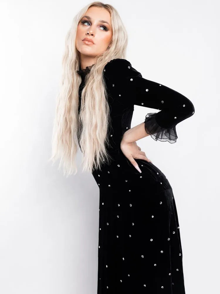 Woman wearing a black dress with white polka dots against a white background