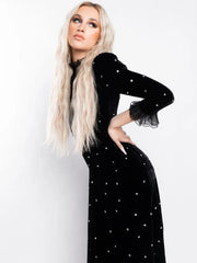 Woman wearing a black dress with white polka dots against a white background