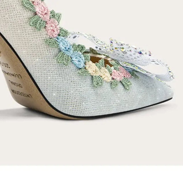 High-heeled shoe with floral embellishments on a light background