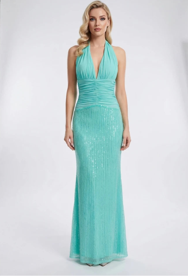 Woman wearing a teal evening gown in a studio setting