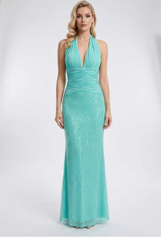 Woman wearing a teal evening gown in a studio setting