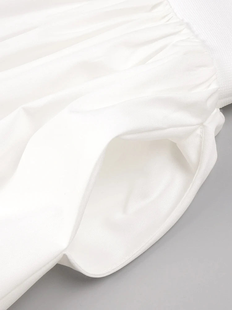 Close-up of a white satin fabric with folds on a gray background