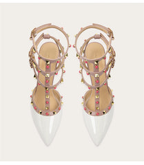 Pair of studded high-heeled shoes with clear soles on a white background