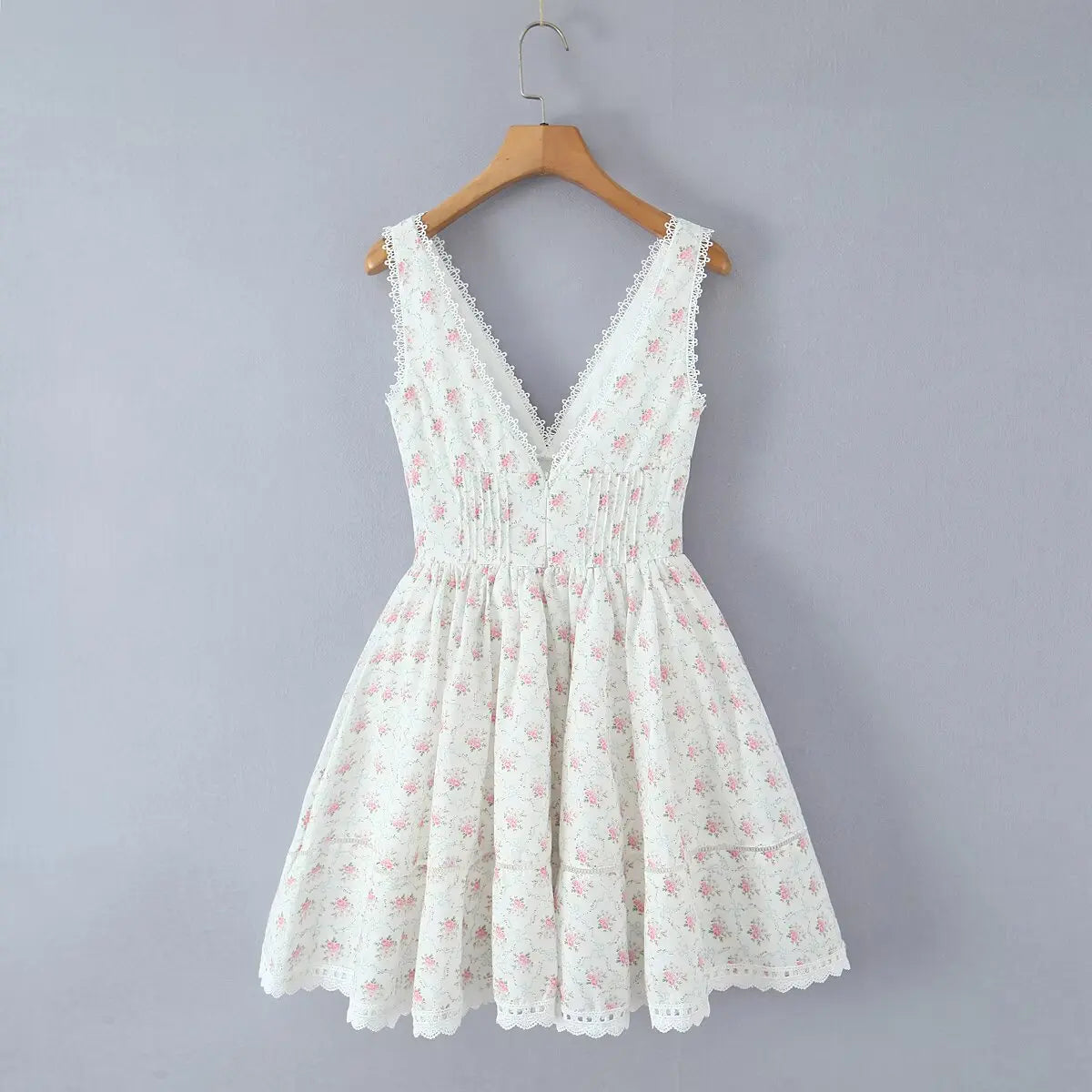 White floral dress on a hanger against a gray background