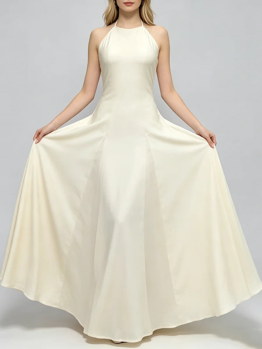 Woman holding the hem of a cream halter neck a-line maxi dress with pleats.