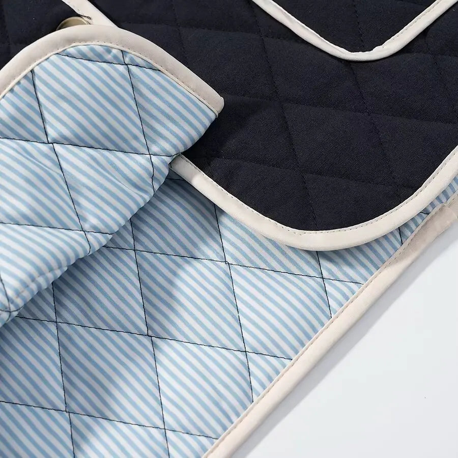 Quilted fabric with blue and white striped pattern on a dark background