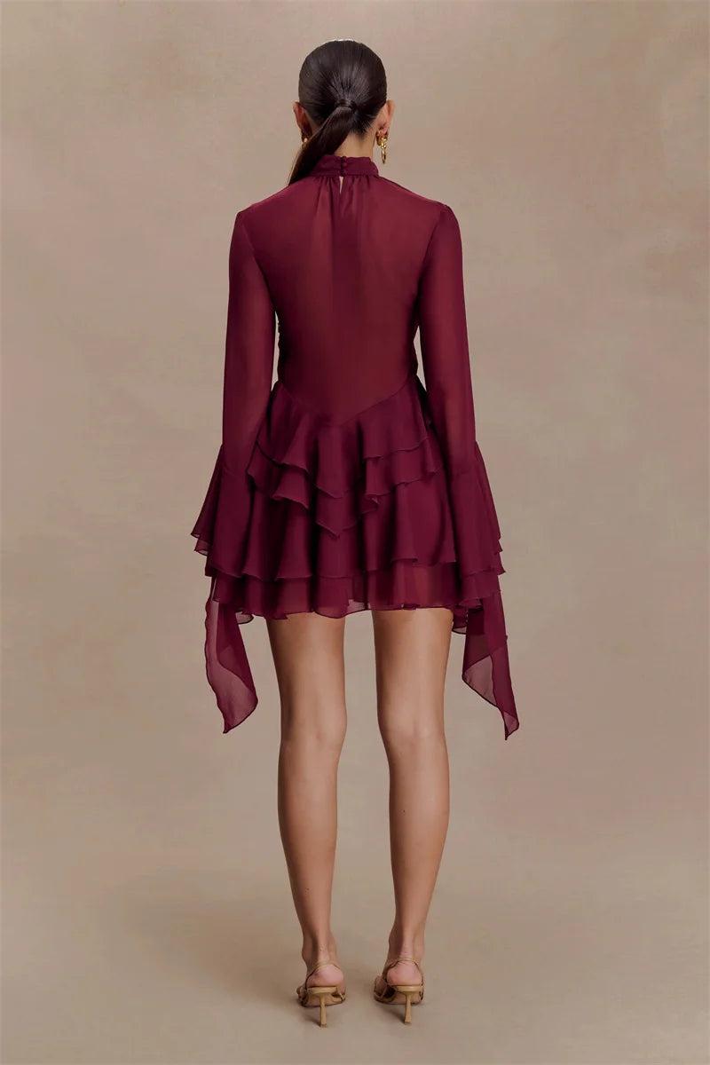 Maroon dress with ruffled layers on a beige background