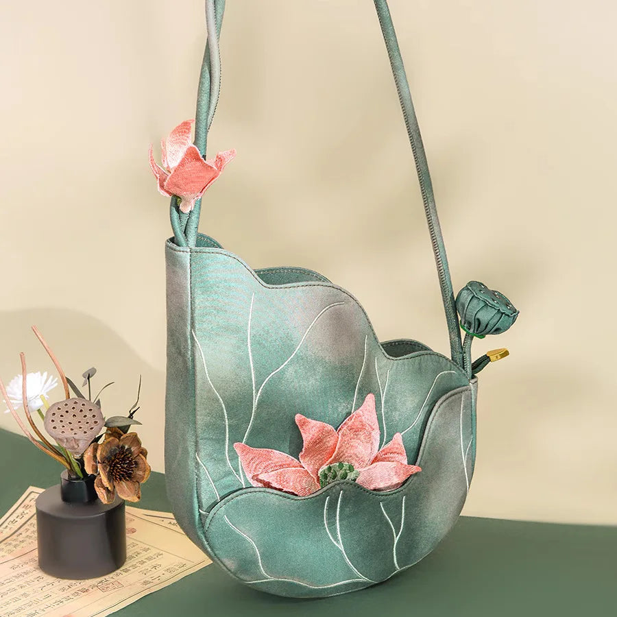 Green fabric bag with pink floral decorations on a beige background