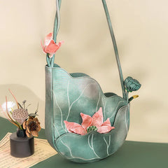 Green fabric bag with pink floral decorations on a beige background