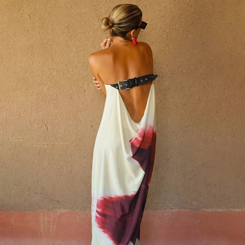 Woman wearing a tie-dye dress with a belt against a beige wall